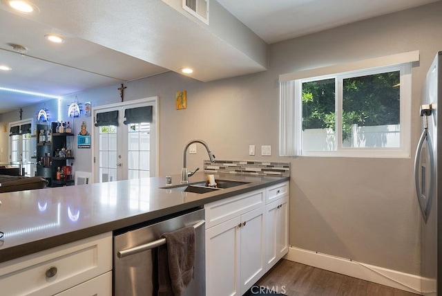 1192 Mitchell Ave Unit 66, Tustin, CA 92780 - kitchen with appliances with stainless steel finishes, a sink, dark wood-style flooring, dark countertops, and white cabinetry