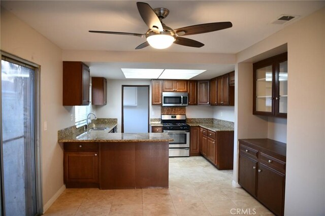 12026 York Ave, Hawthorne, CA 90250 - kitchen featuring appliances with stainless steel finishes, a peninsula, a ceiling fan, dark stone countertops, and light tile patterned floors