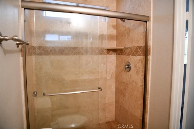 bathroom featuring toilet and a stall shower