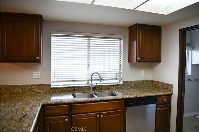 kitchen featuring dark countertops, dishwasher, and a sink