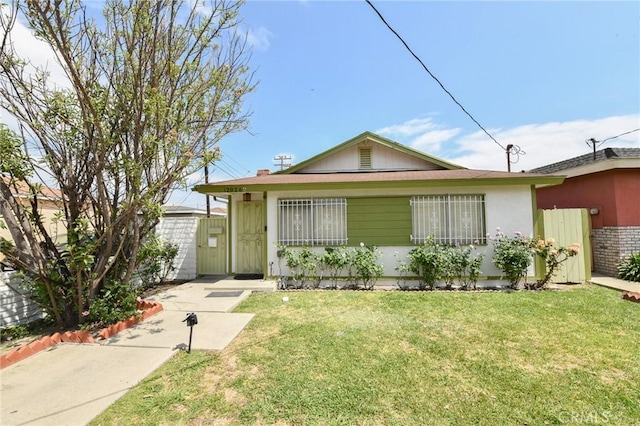 view of front of property featuring fence and a front lawn