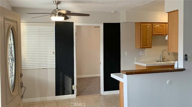 12026 York Ave, Hawthorne, CA 90250 - kitchen with ceiling fan, light tile patterned flooring, backsplash, and light carpet
