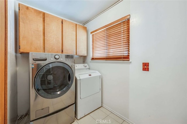 clothes washing area featuring cabinet space, independent washer and dryer, light tile patterned flooring, and baseboards