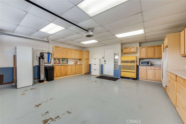 garage featuring a garage door opener and freestanding refrigerator