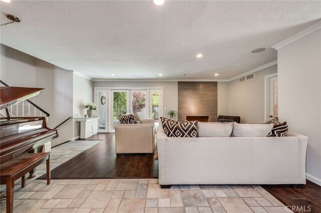 living area with crown molding, visible vents, recessed lighting, wood finished floors, and baseboards