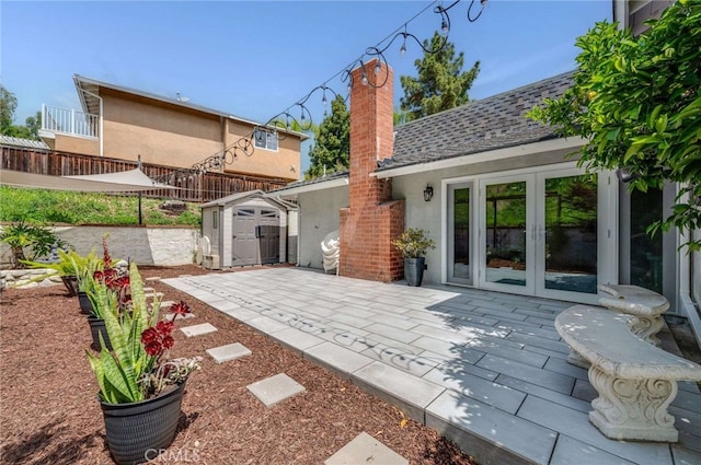 rear view of property featuring an outbuilding, a storage shed, stucco siding, a chimney, and french doors