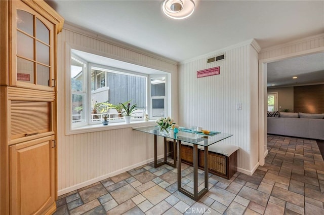 dining space with ornamental molding, baseboards, visible vents, and stone finish flooring