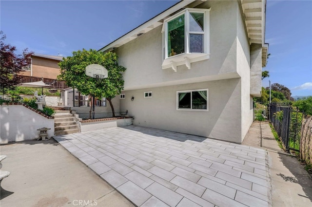 back of property featuring a patio, stucco siding, and fence