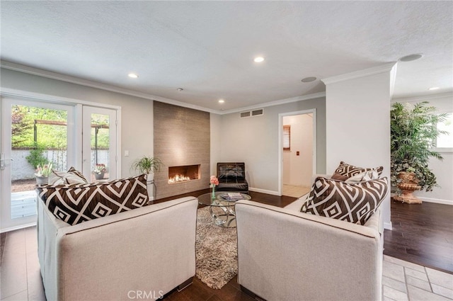 living area with recessed lighting, visible vents, a large fireplace, and ornamental molding