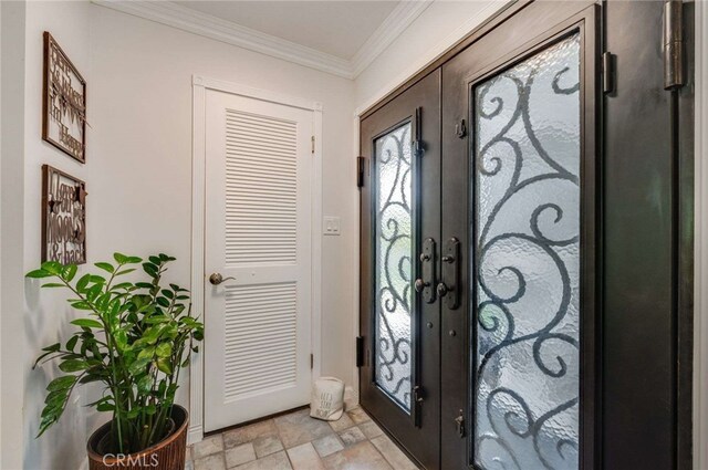 foyer featuring french doors, stone finish floor, and ornamental molding