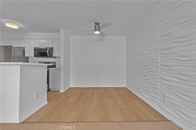 28121 Highridge Rd Unit 402, Rancho Palos Verdes, CA 90275 - kitchen with baseboards, light countertops, white cabinets, appliances with stainless steel finishes, and light wood finished floors