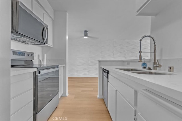 28121 Highridge Rd Unit 402, Rancho Palos Verdes, CA 90275 - kitchen featuring light countertops, white cabinetry, stainless steel appliances, light wood finished floors, and a sink