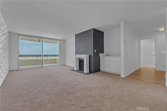 28121 Highridge Rd Unit 402, Rancho Palos Verdes, CA 90275 - unfurnished living room featuring a sink, carpet, a brick fireplace, and expansive windows