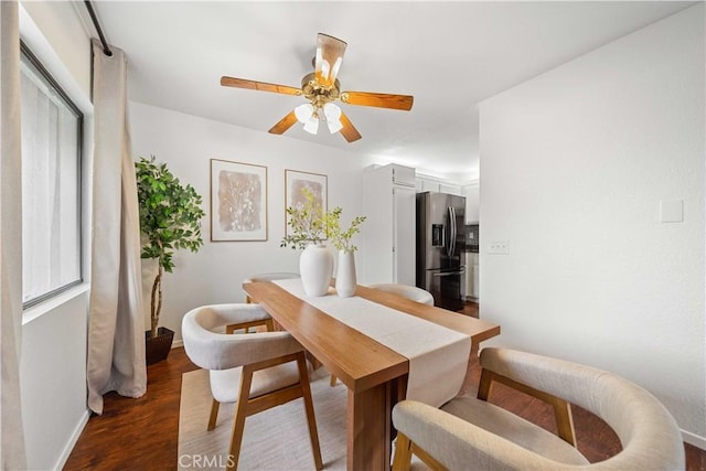 dining area featuring ceiling fan, baseboards, and dark wood-type flooring