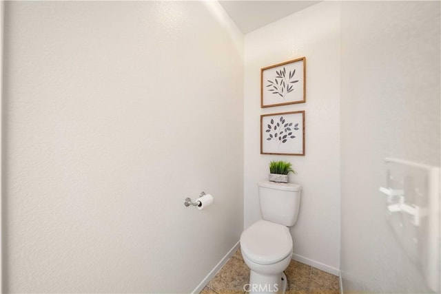 bathroom featuring tile patterned flooring, toilet, and baseboards