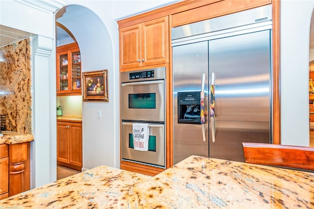 1550 Hibiscus Ave, Azusa, CA 91702 - kitchen featuring arched walkways, light stone countertops, and stainless steel appliances