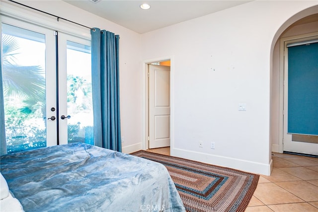 1550 Hibiscus Ave, Azusa, CA 91702 - bedroom featuring light tile patterned floors, arched walkways, recessed lighting, french doors, and baseboards