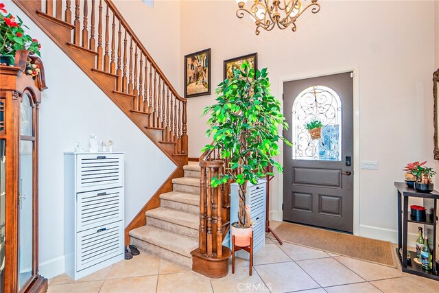 1550 Hibiscus Ave, Azusa, CA 91702 - foyer entrance featuring baseboards, an inviting chandelier, a high ceiling, stairs, and tile patterned floors