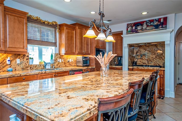 1550 Hibiscus Ave, Azusa, CA 91702 - kitchen with recessed lighting, light tile patterned floors, light stone countertops, brown cabinetry, and a sink