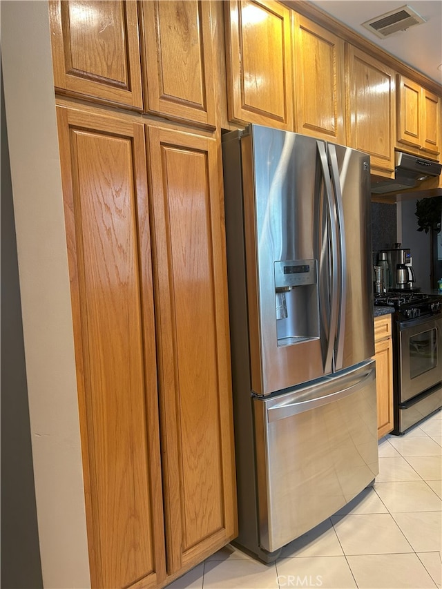 16624 Kelsloan St, Lake Balboa, CA 91406 - kitchen with appliances with stainless steel finishes, under cabinet range hood, light tile patterned floors, brown cabinetry, and dark countertops