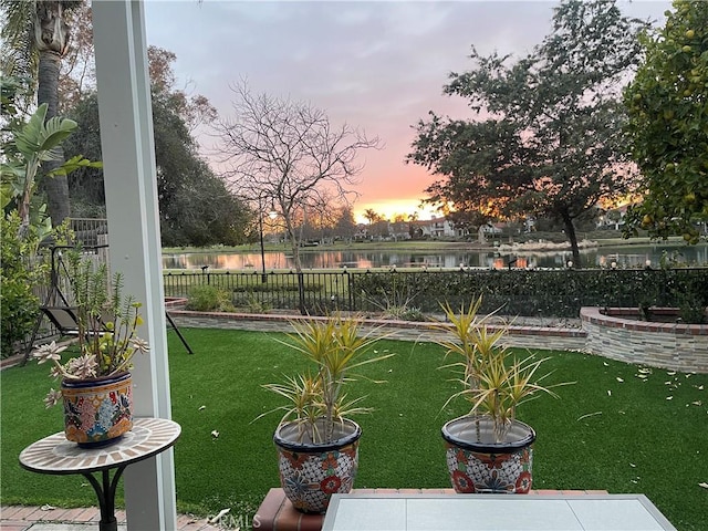view of yard with fence and a water view