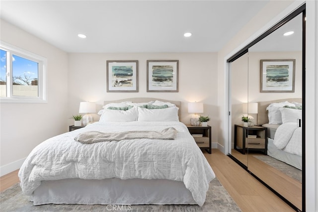 bedroom featuring light wood finished floors, a closet, and baseboards