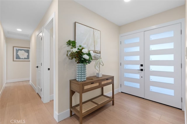 foyer with light wood-style flooring, recessed lighting, and baseboards
