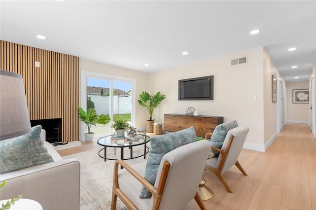 living area with light wood-style floors, baseboards, visible vents, and recessed lighting