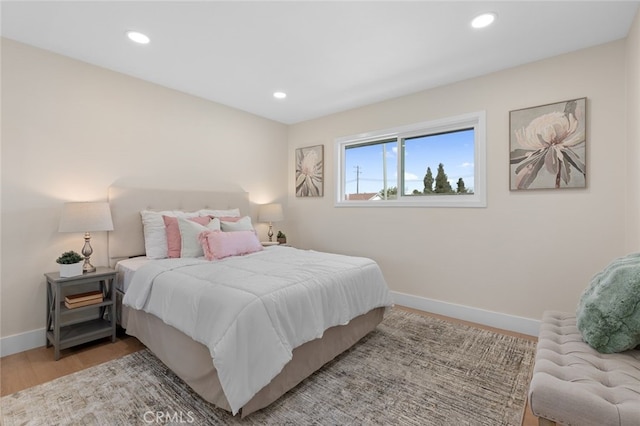 bedroom featuring wood finished floors, baseboards, and recessed lighting
