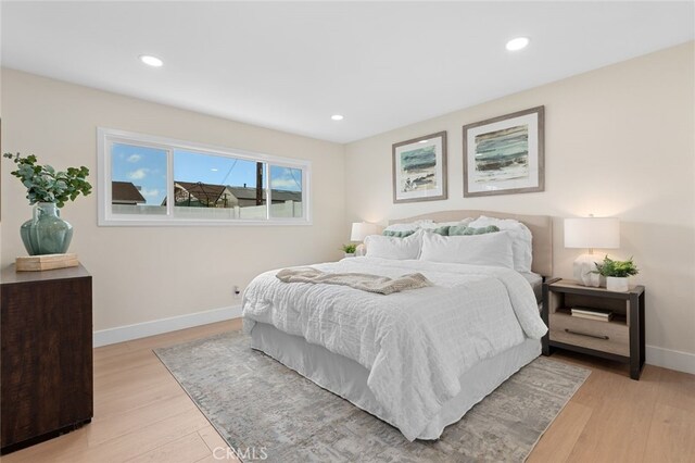 bedroom with recessed lighting, light wood-type flooring, and baseboards