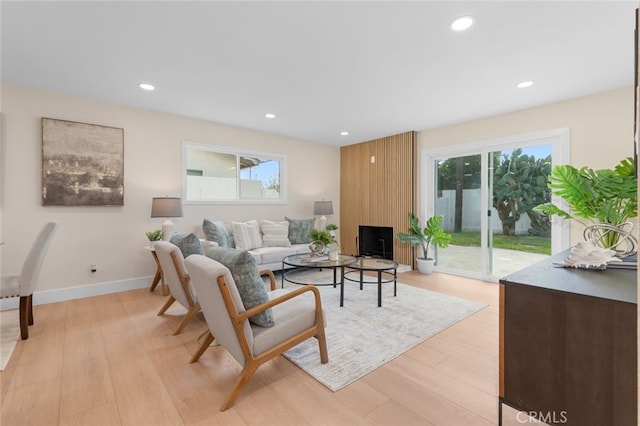 living room with a healthy amount of sunlight, light wood finished floors, baseboards, and recessed lighting