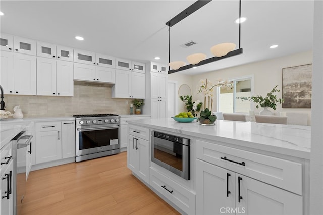 kitchen featuring tasteful backsplash, recessed lighting, white cabinets, visible vents, and appliances with stainless steel finishes