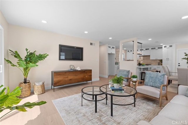 living room with visible vents, light wood-style flooring, recessed lighting, and baseboards