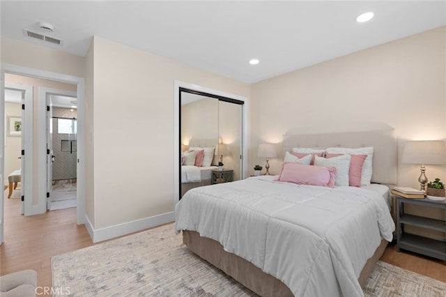 bedroom featuring light wood-style floors, a closet, baseboards, and visible vents