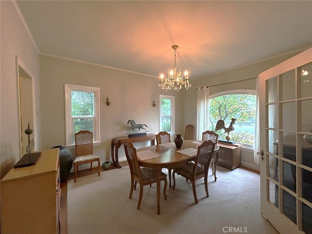 dining room featuring crown molding, light colored carpet, and a notable chandelier