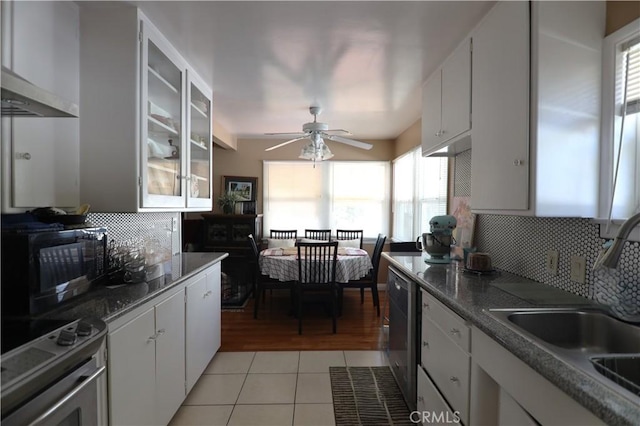 kitchen featuring wall chimney exhaust hood, a sink, black microwave, electric range, and light tile patterned flooring