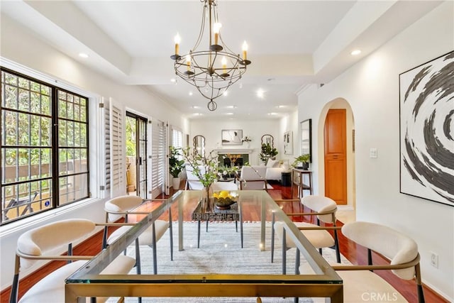 dining space with recessed lighting, baseboards, arched walkways, and a notable chandelier