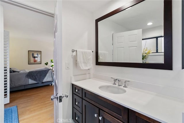 bathroom featuring recessed lighting, wood finished floors, connected bathroom, and vanity