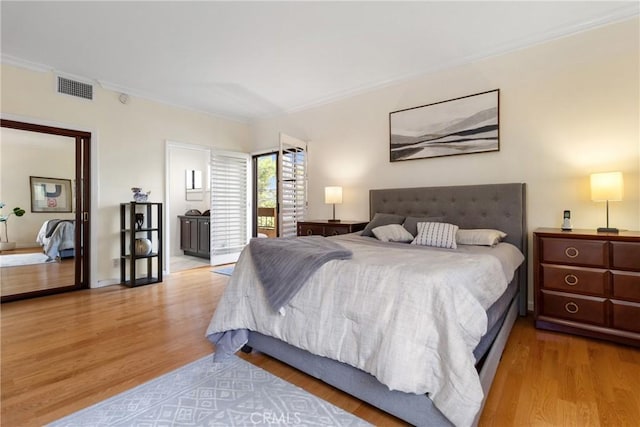 bedroom featuring crown molding, wood finished floors, and visible vents