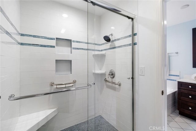 full bath featuring vanity, tile patterned flooring, and a stall shower