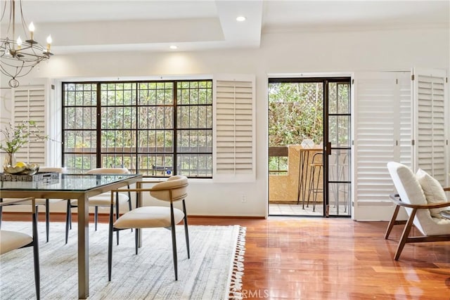 dining space with baseboards, an inviting chandelier, wood finished floors, and recessed lighting