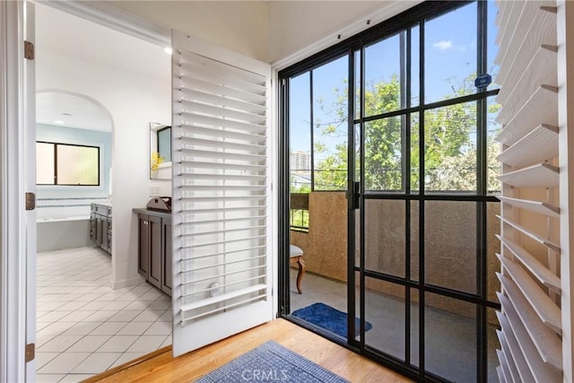 entryway featuring arched walkways and light wood-style floors