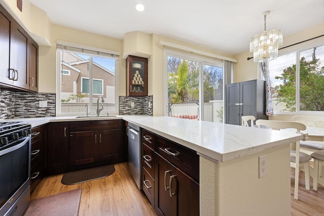 11869 Spruce Run Dr Unit B, San Diego, CA 92131 - kitchen featuring appliances with stainless steel finishes, light wood finished floors, a peninsula, tasteful backsplash, and a chandelier