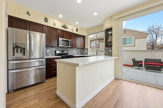 11869 Spruce Run Dr Unit B, San Diego, CA 92131 - kitchen with stainless steel appliances, light wood-style flooring, dark brown cabinets, decorative backsplash, and light countertops