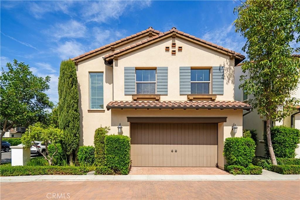 165 Hargrove, Irvine, CA 92620 - mediterranean / spanish home featuring a garage, stucco siding, a tiled roof, and decorative driveway