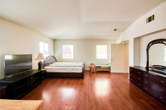 bedroom featuring baseboards, vaulted ceiling, dark wood finished floors, and visible vents
