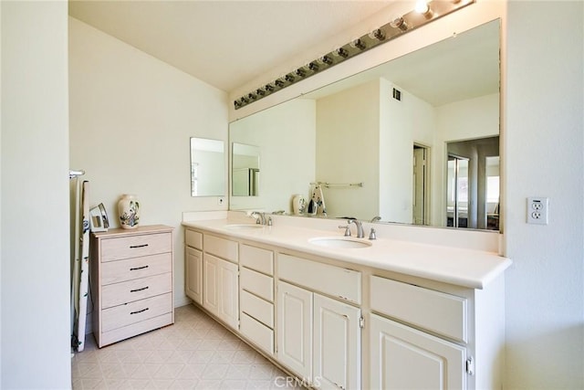bathroom featuring tile patterned floors, double vanity, and a sink