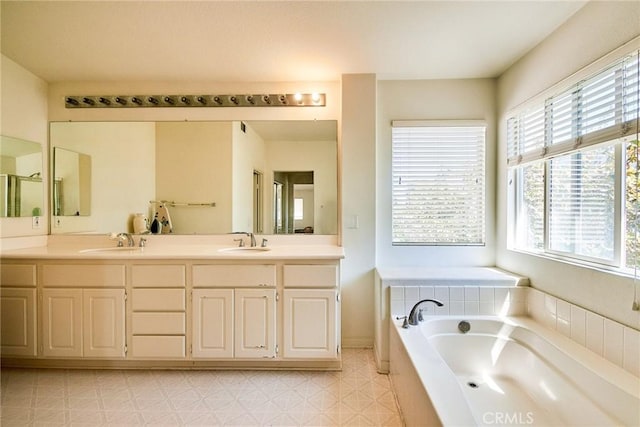 full bathroom with a sink, double vanity, and a garden tub