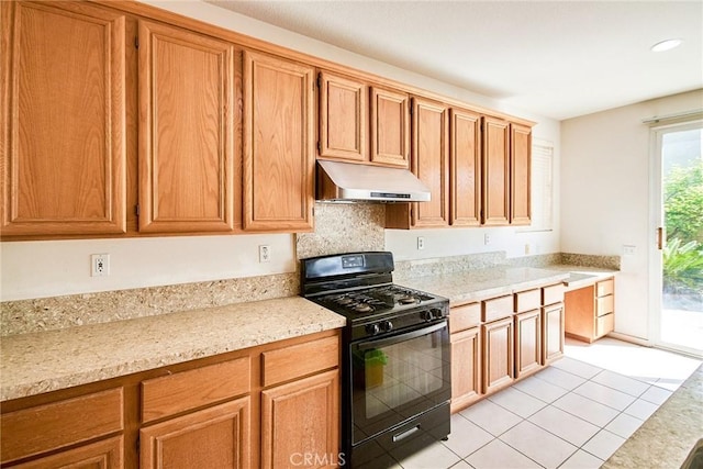 kitchen featuring light tile patterned floors, under cabinet range hood, brown cabinetry, recessed lighting, and gas stove