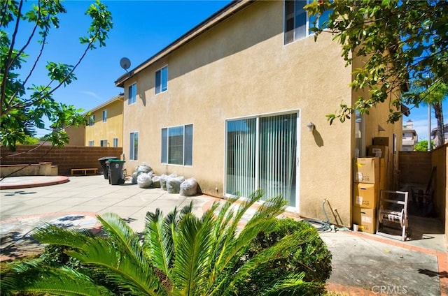 back of house with a patio area, stucco siding, and fence